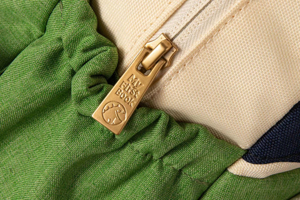 A close up, detailed photo of the high-quality, waterproof backpack zipper that is included with the My First Book Busy Farm busy book. 
