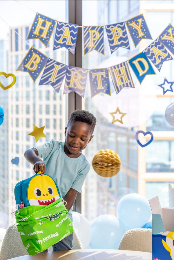 A young boy is excited to receive the Baby Shark busy book as a gift, because it’s a great baby gift with Montessori style play and activities that kids will enjoy for years. 