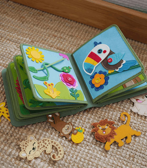 MyFirstBook fabric busy book open showing flower and bird pages with colorful felt shapes and detachable animals