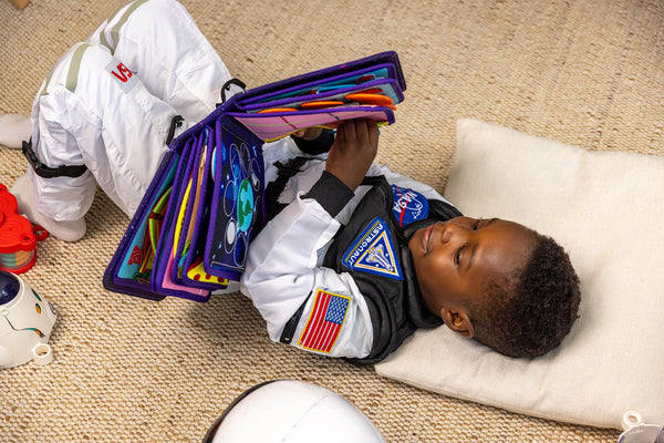 Boy dressed as an outer space astronaut playing with My First Book Space busy book, engaged in the Montessori inspired play and sensory activities. Makes a great baby gift.