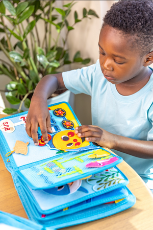 A young boy enjoying the screen-free fun and building fine motor skills through Montessori inspired play with the Baby Shark busy book. Makes a great baby gift. 
