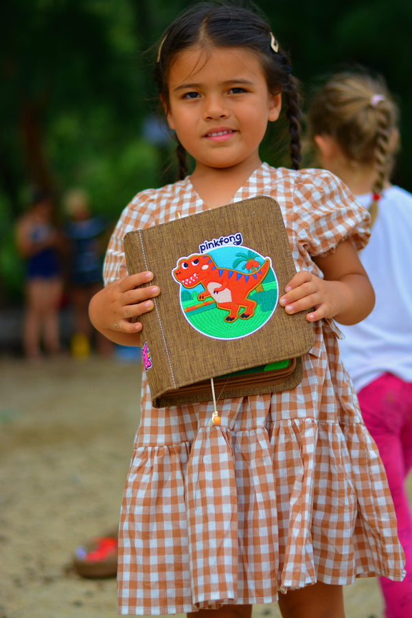 This picture shows a girl being gifted the Dinosaur busy book. The book makes great baby gift.