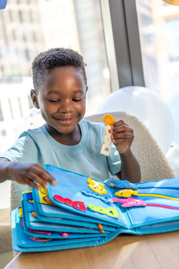 A young boy enjoying the storytelling possibilities and Montessori inspired play of the My First Book Baby Shark busy book. Makes a great baby gift. 
