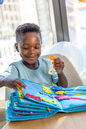 A young boy enjoying the storytelling possibilities and Montessori inspired play of the My First Book Baby Shark busy book. Makes a great baby gift. 
